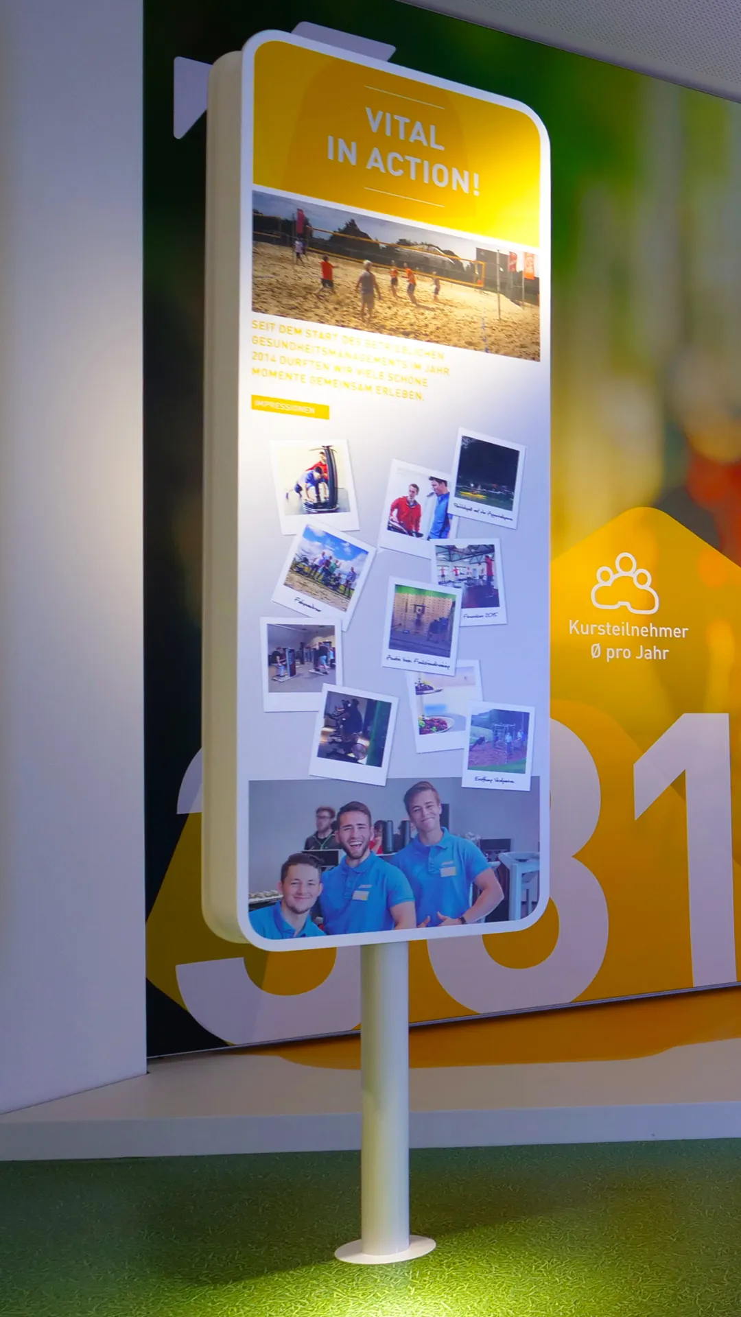 Kommunikationskonzept für Showroom für ABUS-Kransysteme mit Infostele mit Collage aus Teamfotos und Aktivitäten, VITAL-Raum als Teil der Arbeitgebermarke