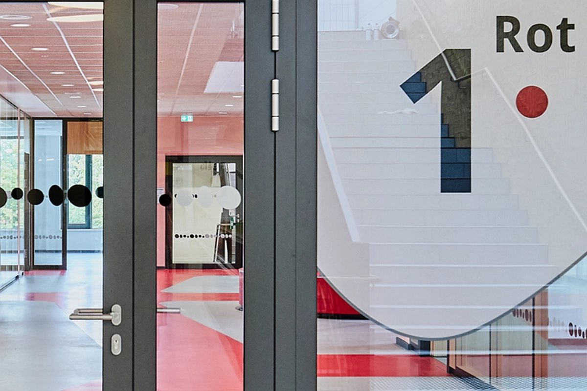 Innenaufnahme der Gesamtschule Waldschlösschen in Velbert mit Ausschnitten des neu entwickelten Leitsystems. Umsetzung in Zusammenarbeit mit Goldbeck West und der R211-Agentur.