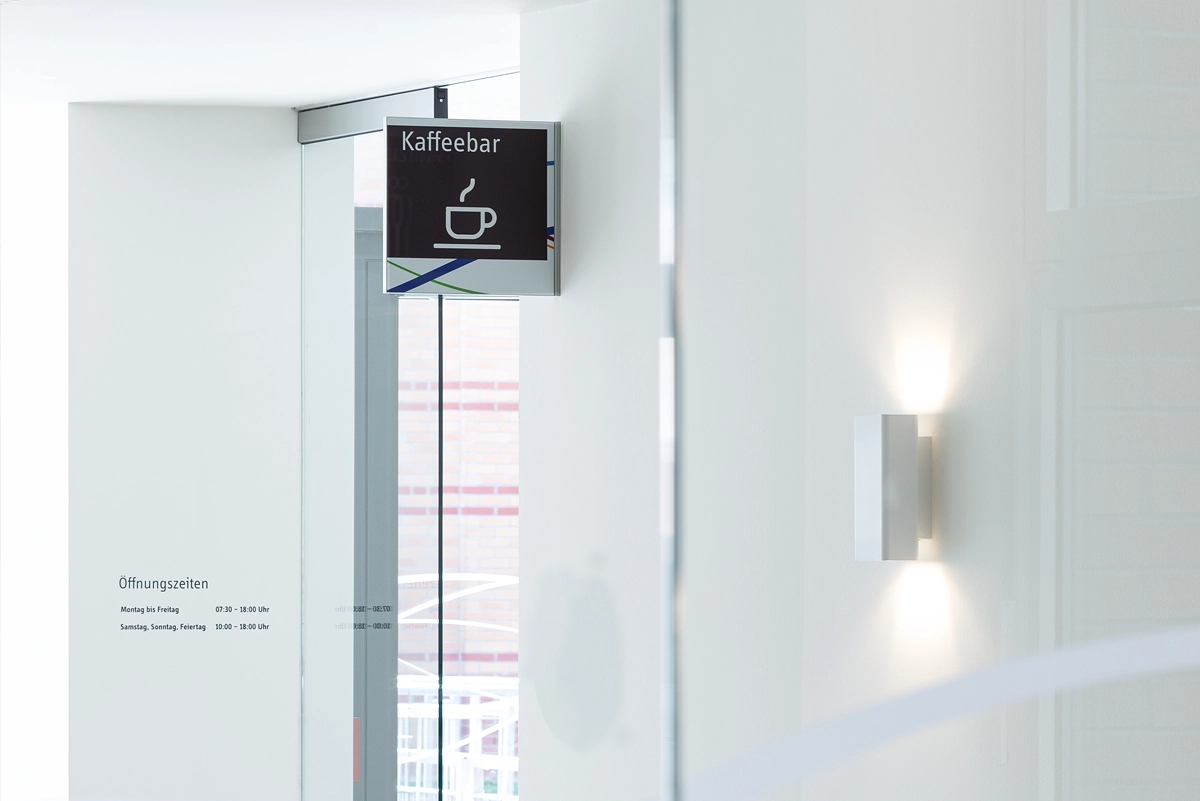 Nahaufnahme der Wegweiser-Beschilderung zum Café innerhalb der Städtische Kliniken Mönchengladbach. Konzept und Umsetzung durch die R211-Agentur.