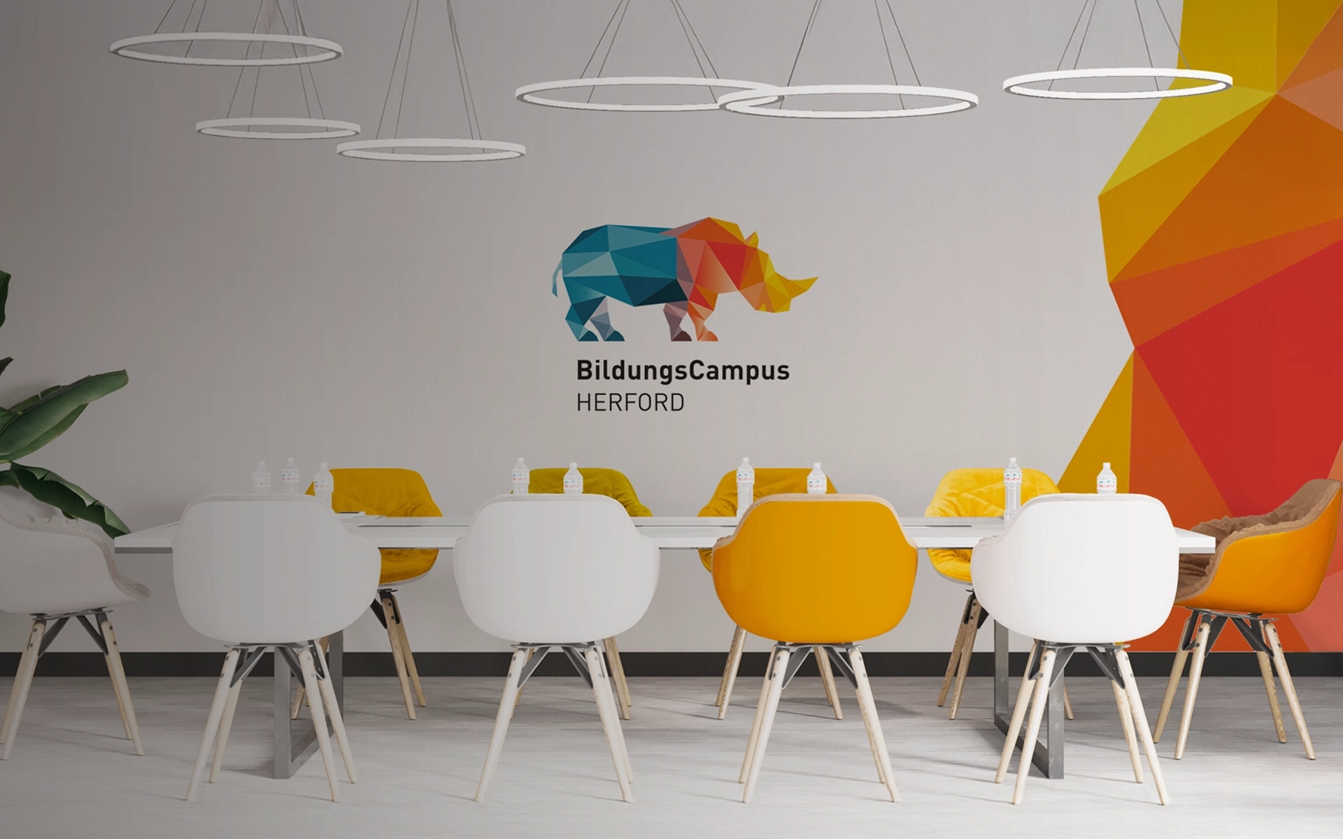 Innenaufnahme eines Konferenzraums auf dem BildungsCampus Herford der SEH mit Branding im Hintergrund. Konzeption durch R211-Agentur.