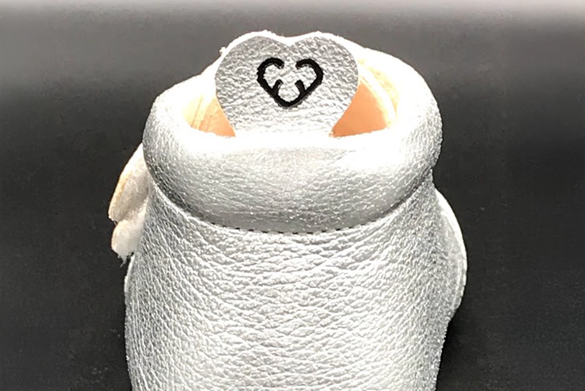 Detailaufnahme eines Carponi-Krabbelschuhs mit aufgebrachtem Logo auf der hinteren Schuhlasche – als markenprägendes Element im Produktdesign.