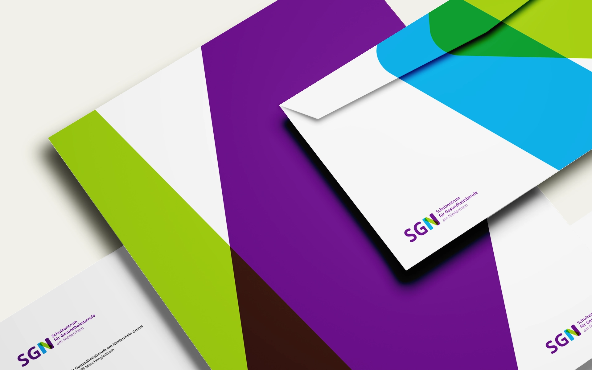 Ansicht der neuen Geschäftsausstattung für das SGN – Schulzentrum für Gesundheitsberufe am Niederrhein, farbenfroh und modern gestaltet für eine junge Zielgruppe. Rebranding-Konzept und Umsetzung durch R211-Agentur.