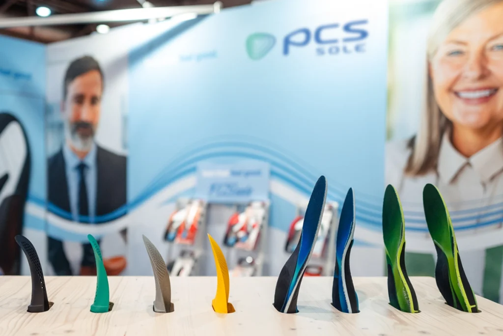 Nahaufnahme des PCS Sole Messestands auf der OTWorld in Leipzig mit Fokus auf Standgestaltung und Markeninszenierung. Design und Umsetzung durch die R211-Agentur.