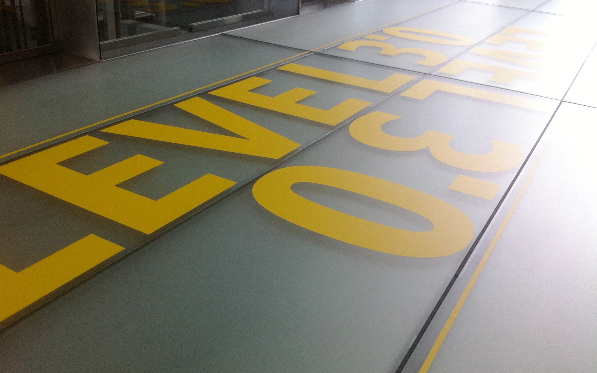 Bodengrafik Schriftzug zur Strukturierurng des Contents der Ausstellung Level 3.0 im Deutsche Post DHL Tower in Bonn