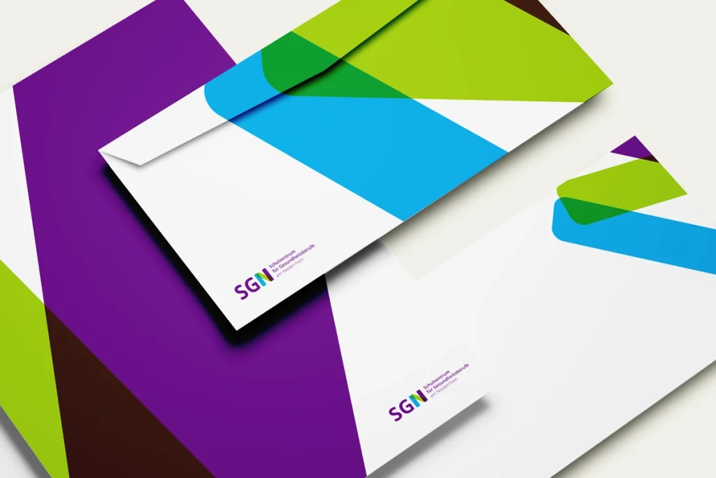 Ansicht der neuen Geschäftsausstattung für das SGN – Schulzentrum für Gesundheitsberufe am Niederrhein, farbenfroh und modern gestaltet für eine junge Zielgruppe. Rebranding-Konzept und Umsetzung durch R211-Agentur.