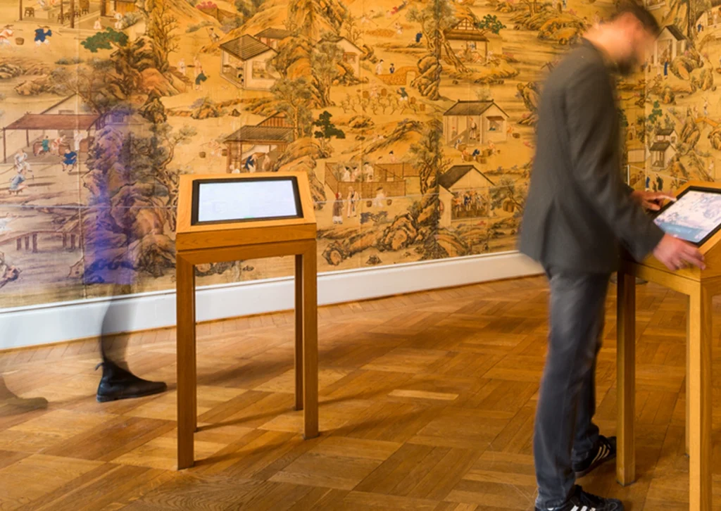 Besucher bedient das User Interface für die Medien-Installation einer Chinesischen Seidentapete als interaktive Station der Stiftung Schloss Dyck